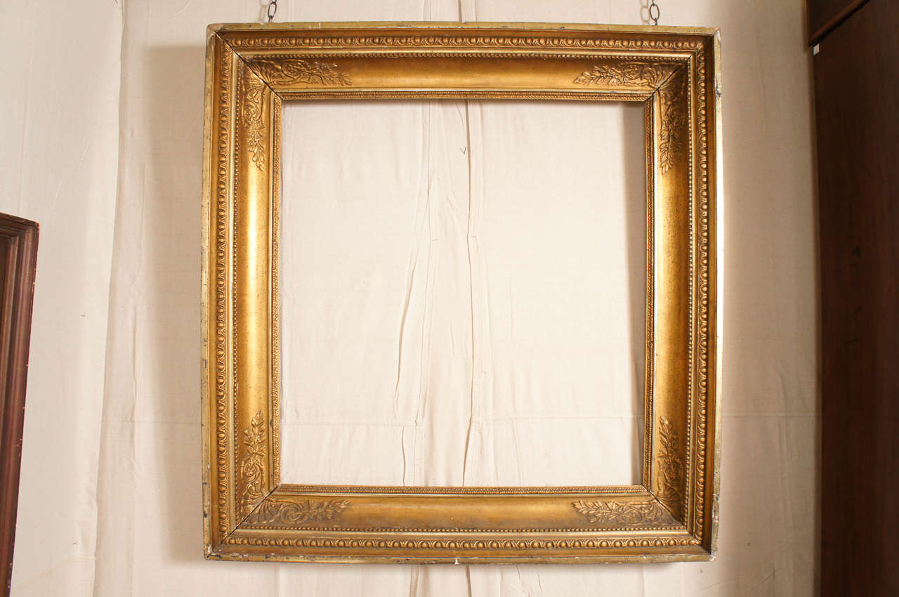 A late 19th century European gilded frame with egg and dart molding and corners decorated with leaves and shells