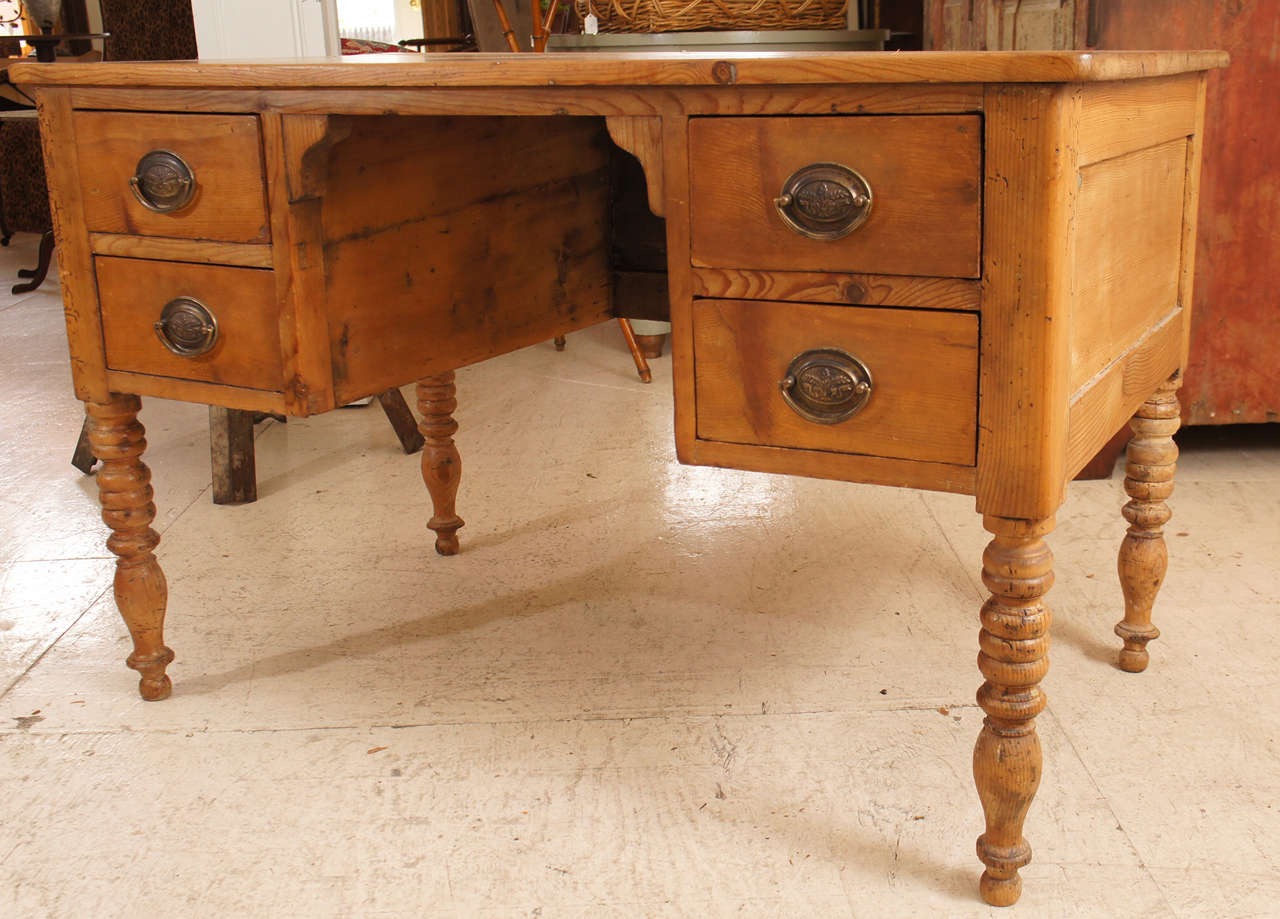 French Provincial pine four-drawer desk, kneehole style with nicely turned legs.  Later drawer pulls.