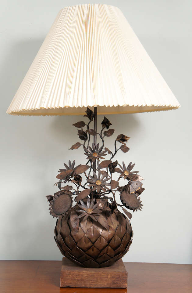 Wrought metal artichoke with sunflowers, butterflies, leaves and
daisies mounted on a wooden block as a lamp. Shade not included.
  