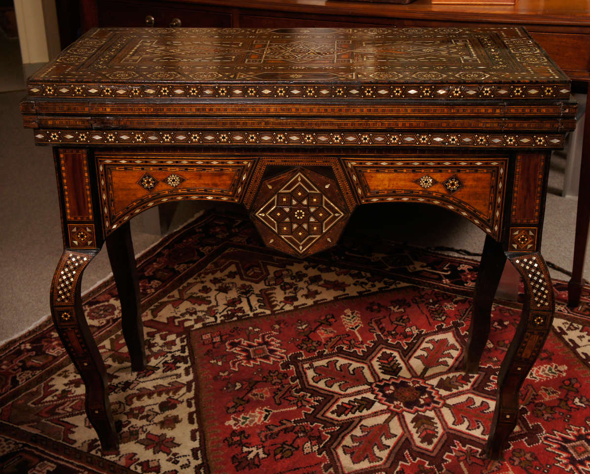 Rare chess and backgammon Syrian games table with a baize covering for card games. Beautifully finished and decorated on all sides with mother of pearl, ebony and bone. Interior has compartments to store game accessories.
Dimensions:
36.5