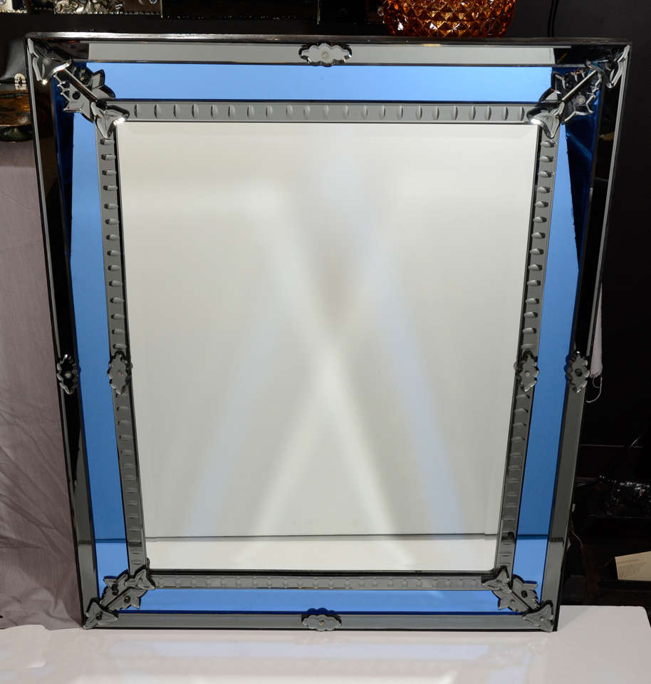 Gorgeous Venetian mirror with colbalt mirrored insets and with smoked grey mirrored borders. All hand beveled with reverse etched designs and almond convex circle details. The mirror also features stylized beveled mirrored rosette fittings.