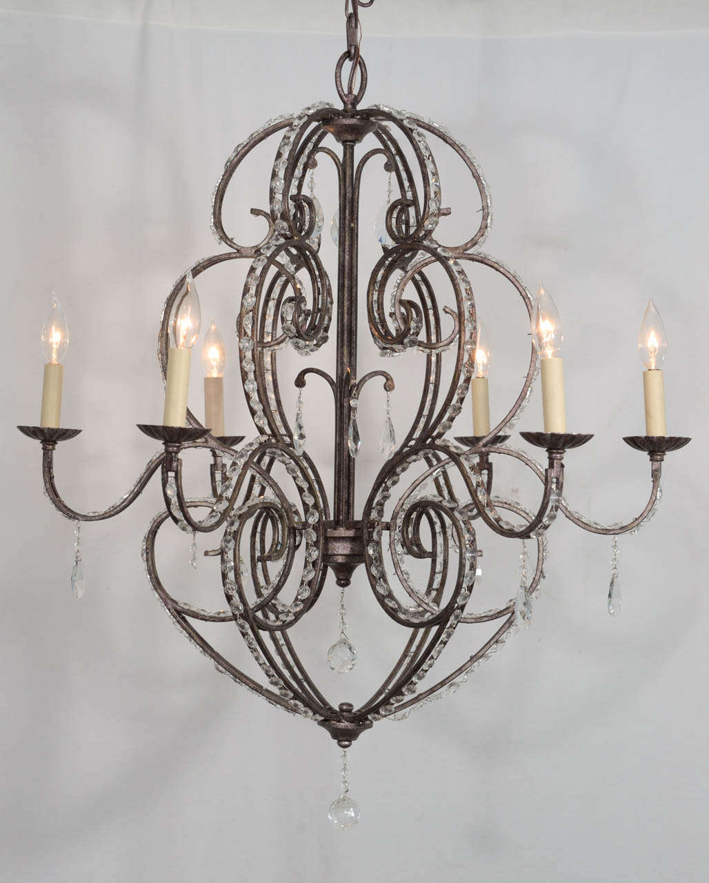 24% lead crystal, scrolling arms, eight-light crystal, bronze iron frame with crystal inserts in all up/down structural elements, delicate boboche and crystal pendants.