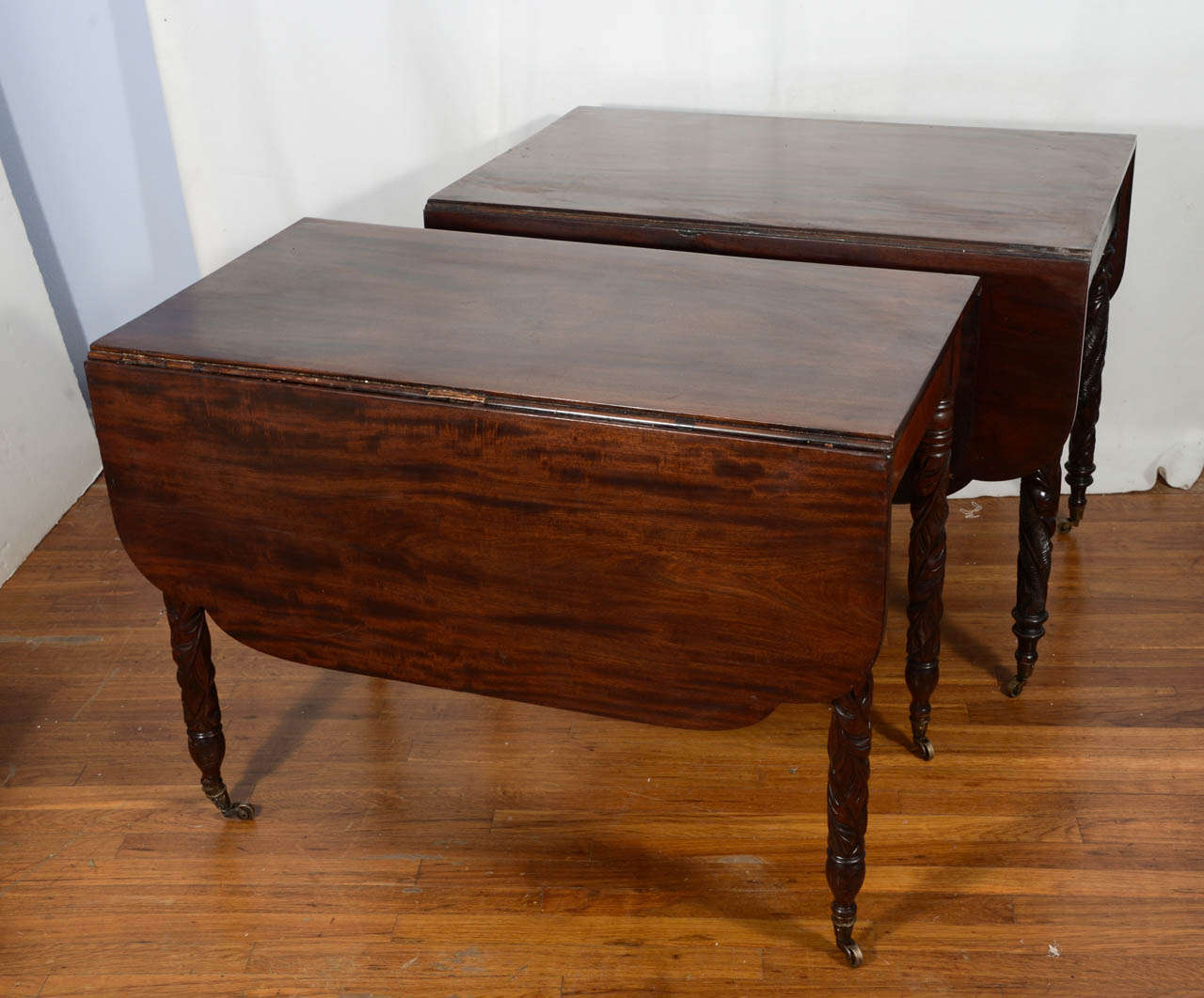 Federal period, Mahogany drop-leaf, tapered, hand-carved acanthus leaf designed legs with brass casters, beautifully finished dining tables. Matching tables however one is 22