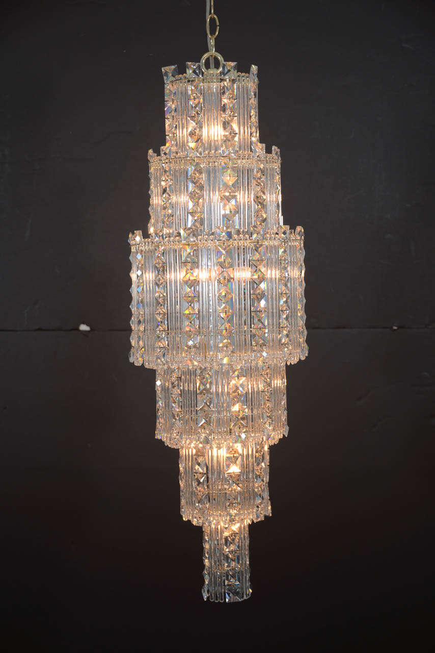 A dazzling Modern pendant chandelier with its heavy lead content crystal will elegantly illuminate any area. Round terraces of beautiful square, jewel like prisms alternating with pencil drops in each graduating row of crystals form a shimmering,