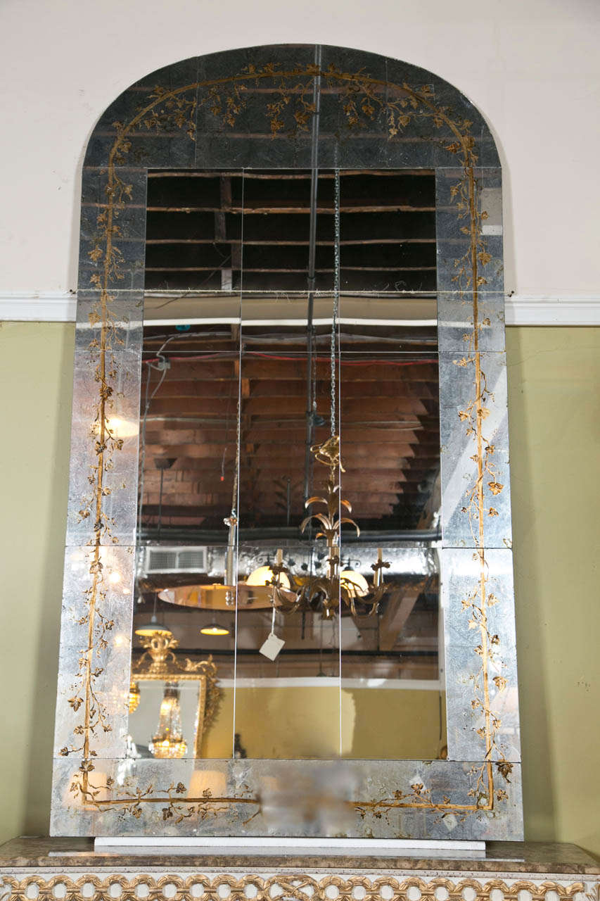 Pair of monumental custom quality mirrors, each having verre eglomise glass panel borders, centering a rectangular paneled looking glass, the border decorated with reverse painted foliage.