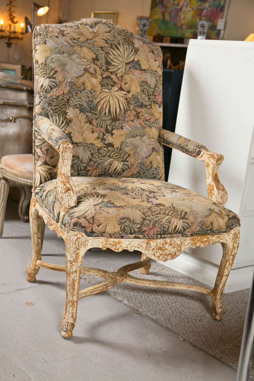 Pair of faueuils a la reine in the French Louis XV taste, overall distressed decorated with chipped paint, upholstered in embroidered fabric, raised on cabriole legs joint with an 