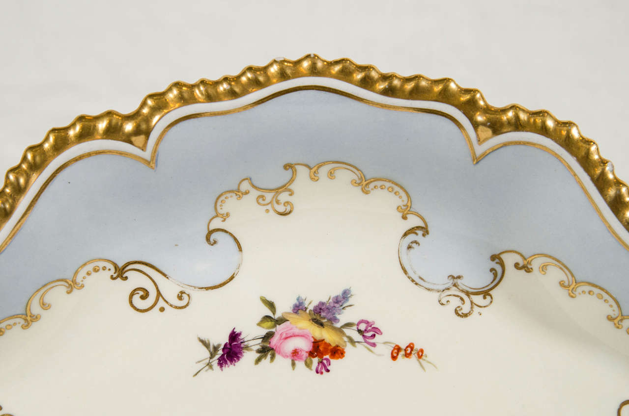 A pair of pale blue Flight Barr Barr Worcester oval-shaped dishes with lavishly glided gold gadrooned edges. The centers are decorated with delicate sprays of hand-painted pink and purple flowers (see image #4).
It is the combination of the soft