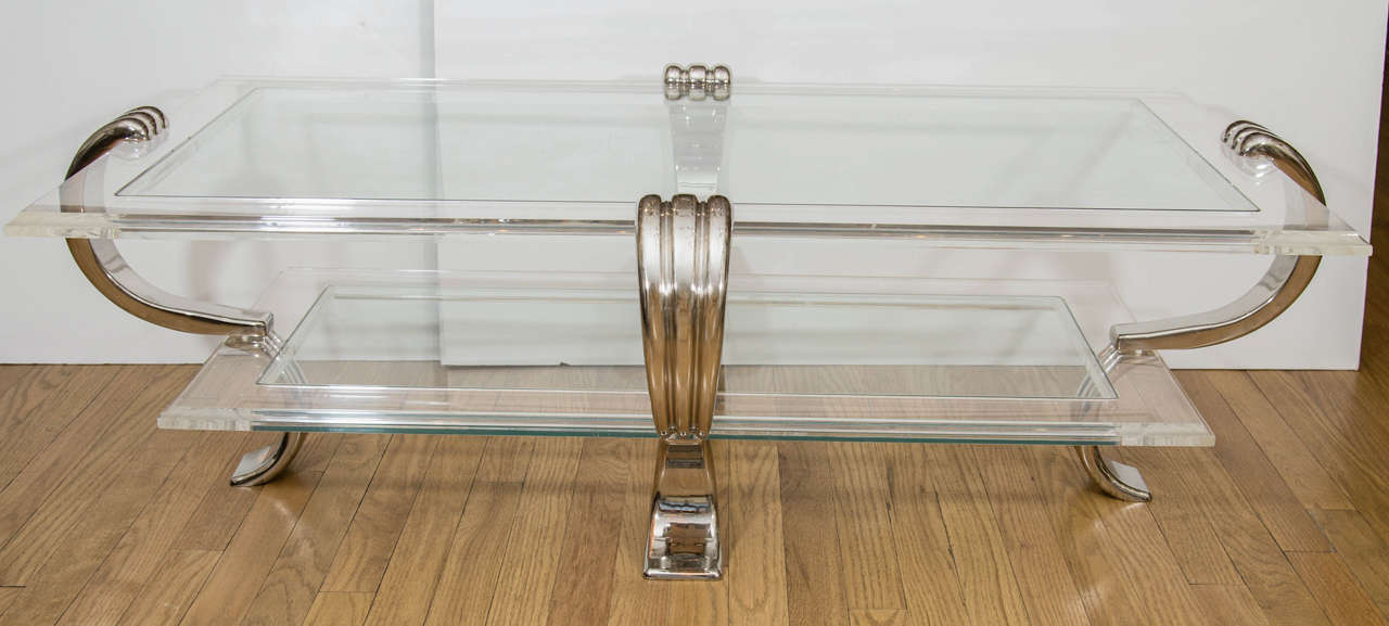 Rectangular, two-tier coffee table with class tops and fluted nickel scroll form supports.