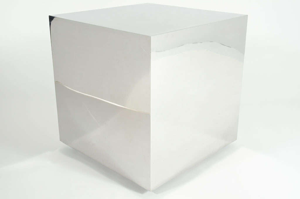 A monolithic occasional table in a perfect cube form with a high polished reflective steel surface, all resting on casters. After Ward Bennett. American, circa 1960.