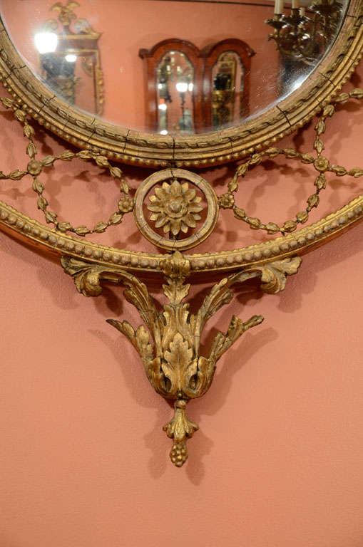 A pair of 19th century giltwood and composition mirrors attributed to C. Nosotti, the convex plates surrounded by Nosotti's signature entwined foliage and with bowknot crest and stiff leaf drop.

Nosotti was an accomplished carver and gilder and