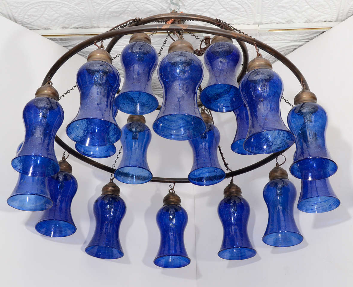 Two-tiered Egyptian chandelier with cobalt bell-shaped glass and bronze rings. Available in custom sizes and with silver finished rings.
