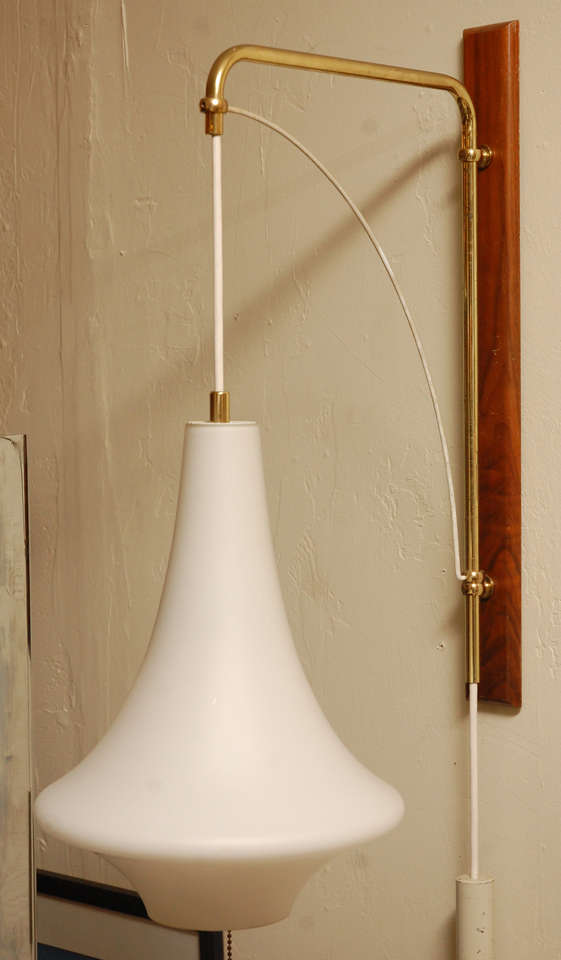 Elegant brass, wood and glass 1960s swing arm wall sconce.
Dimension of glass Height 14