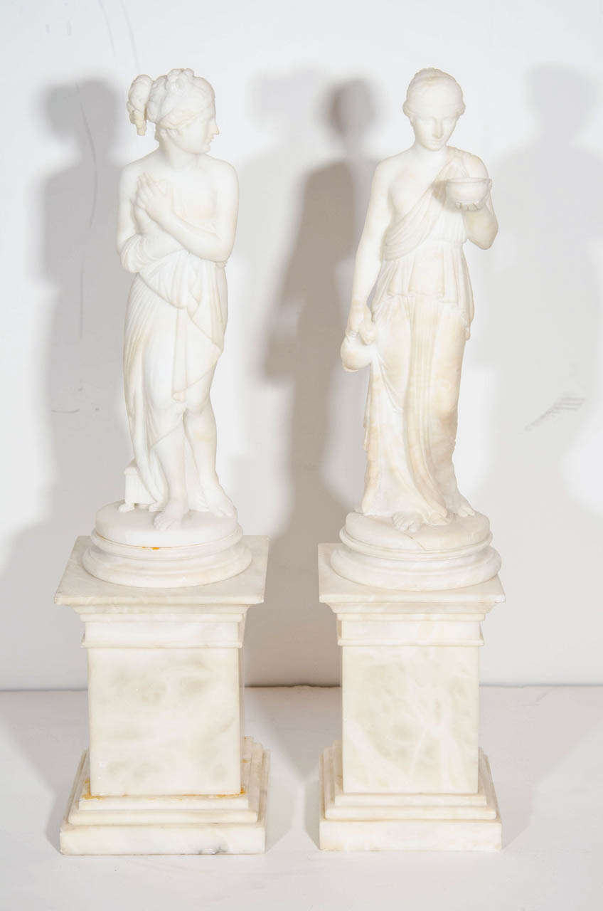 A pair of fine antique neoclassical hand-carved alabaster figures of Grecian ladies on carved alabaster bases.