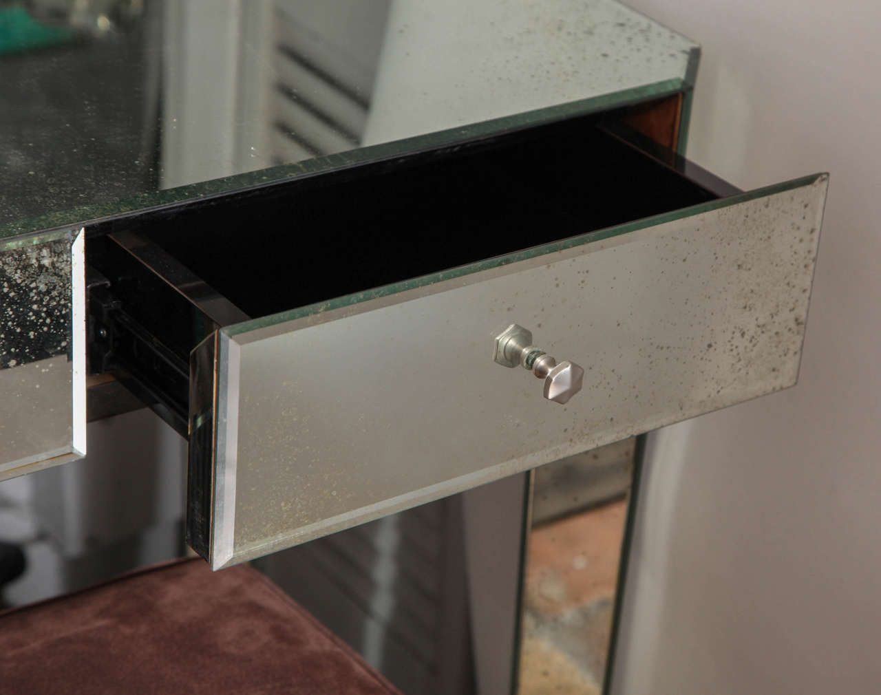 A sleek and stylish modern vanity or desk in distressed mirror.