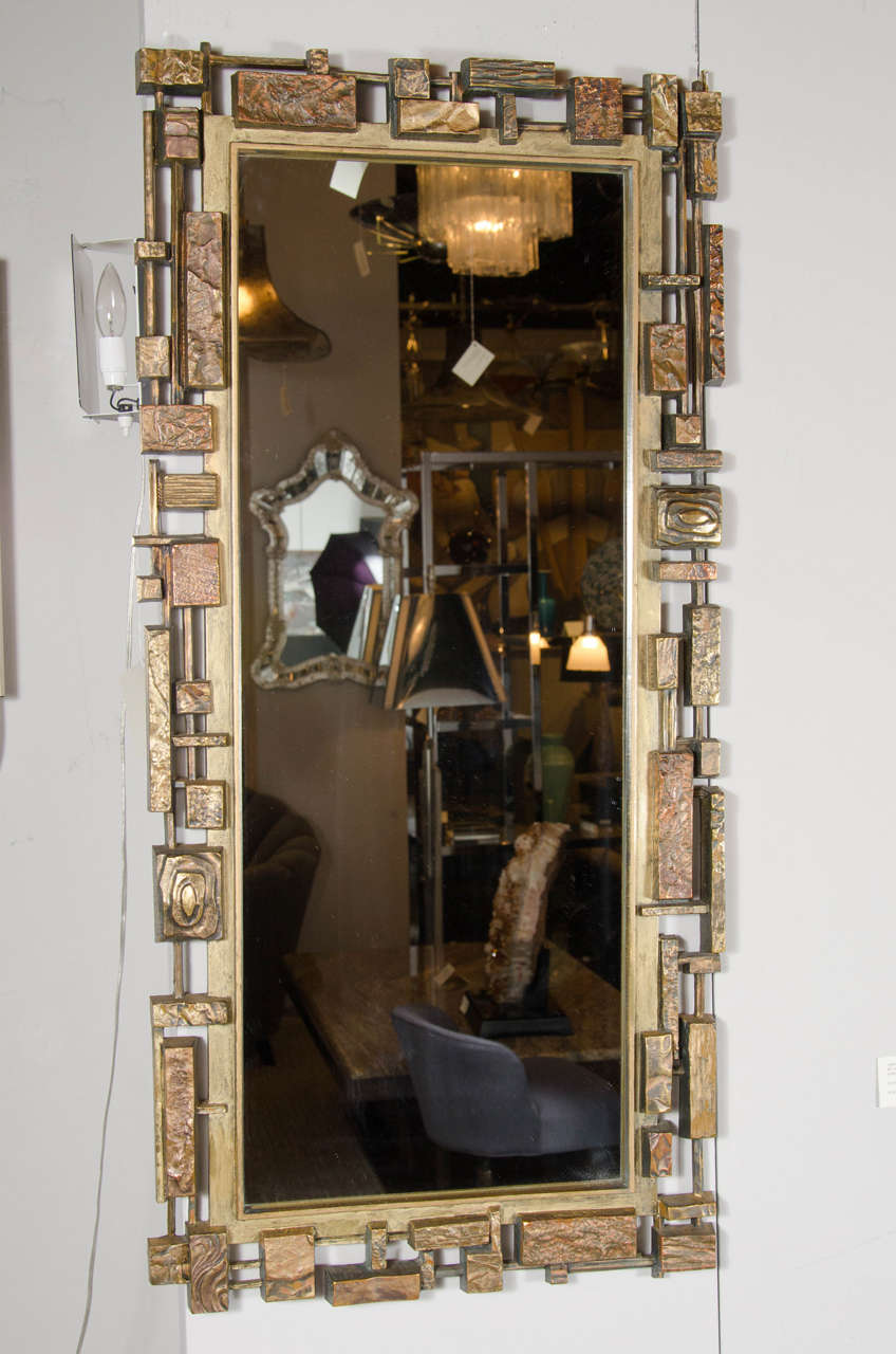 Mid-Century Modernist 'Syroco' Brutalist mirror with gilt detailing.  This mirror features a surround in resin, or syrocco, that is done in beautiful stylized Brutalist design with a gilt finish over the resin.  It has an overall chic floating