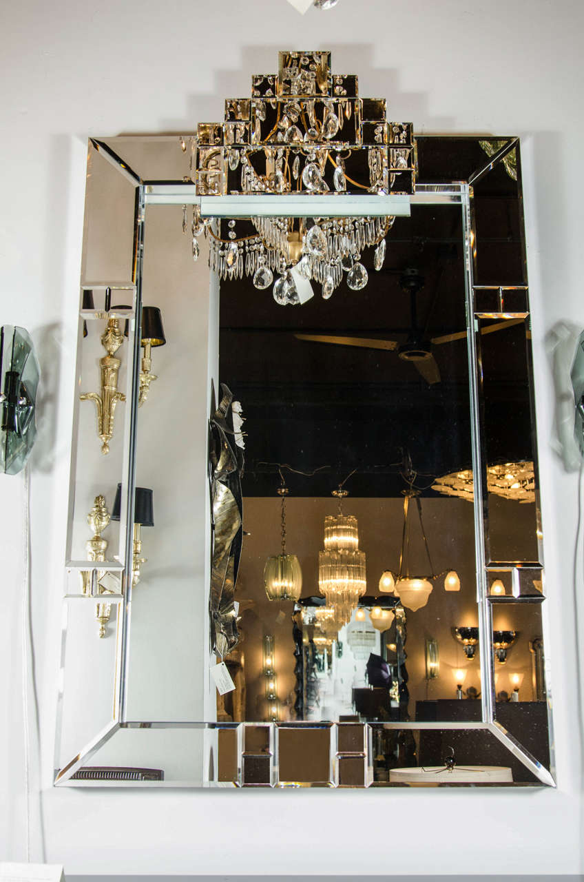 This mirror features a skyscraper Art Deco style design with a shadow box surround with inset beveled mirror panels in a Cubist design.