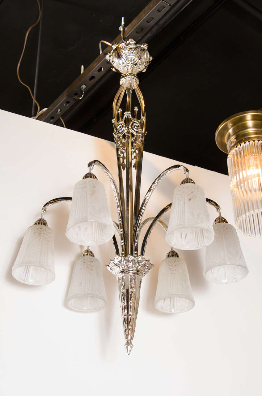 This elegant chandelier was realized in France, circa 1930, by Muller Fre'res- one of the most celebrated lighting ateliers of the period. It features six conical globes in relief frosted glass with Art Deco cubist geometric designs engraved. The