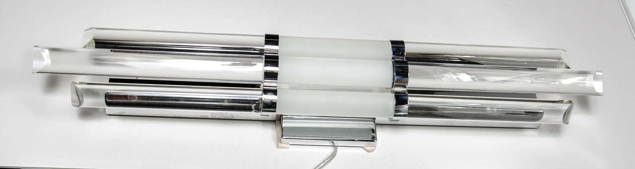 This stunning Mid-Century modernist vanity light.

Mid-Century modernist skyscraper style glass rod vanity light with chrome fittings. This skyscraper style light features three glass rods that are banded together in a curved formation with chrome