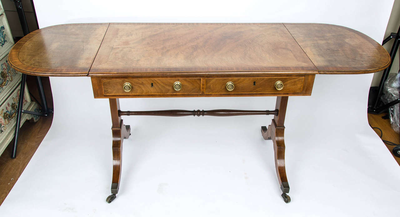A Regency crossbanded satinwood sofa table