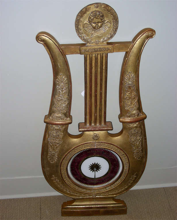 1820s lyre-shaped barometer, without working system. Dial in eglomised glass, with structure in carved and gilt wood, entirely re-gilt and restored.
