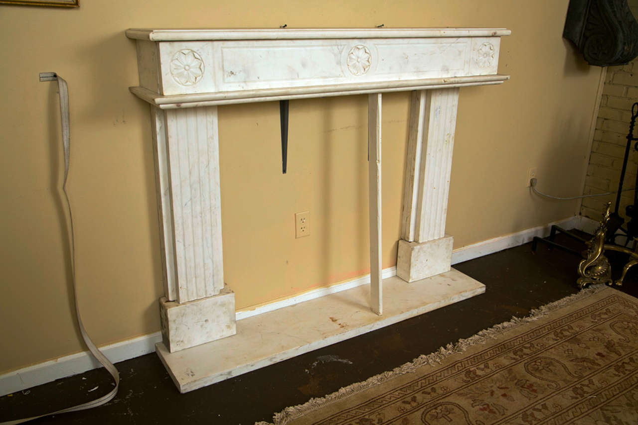 A fine Carrear Marble Fireplace Surround. Solid Marble floorbase having a pair of flanking reeded marble columns supporting a carved marble fireplace top. Inside dimension: 37.5H 37W