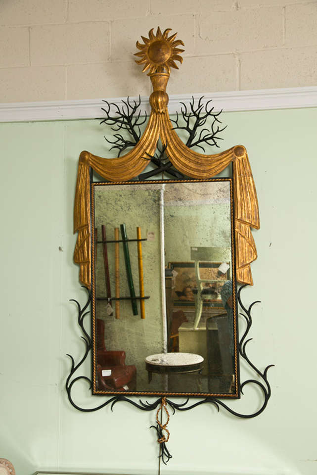An intriging Art Deco style mirror in the manner of Gilbert Poillerat, circa 1960s, a distressed rectangular glass with beautiful iron-work frame, the top crest in the form of soleil and drapery, intertwine with branch-like decoration. Metal.