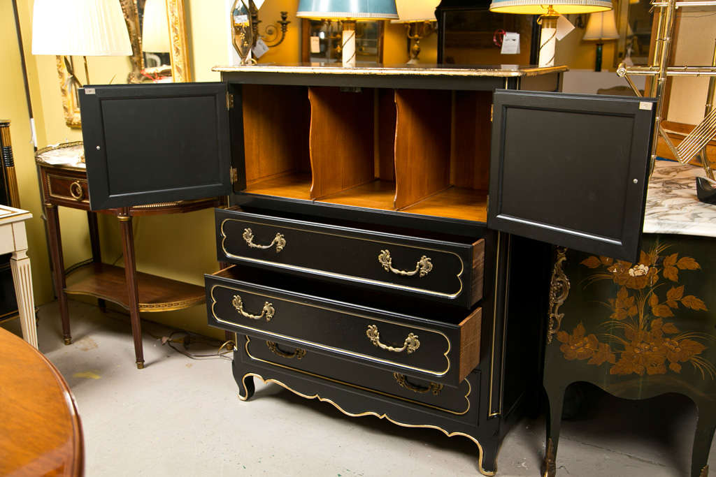 French Louis XV style cabinet on chest, circa 1950s, overall ebonized and parcel-gilt, the top of a cabinet with two gilt-glass door opens to a divided interior, over a conforming case fitted with three drawers, raised on cabriole legs.