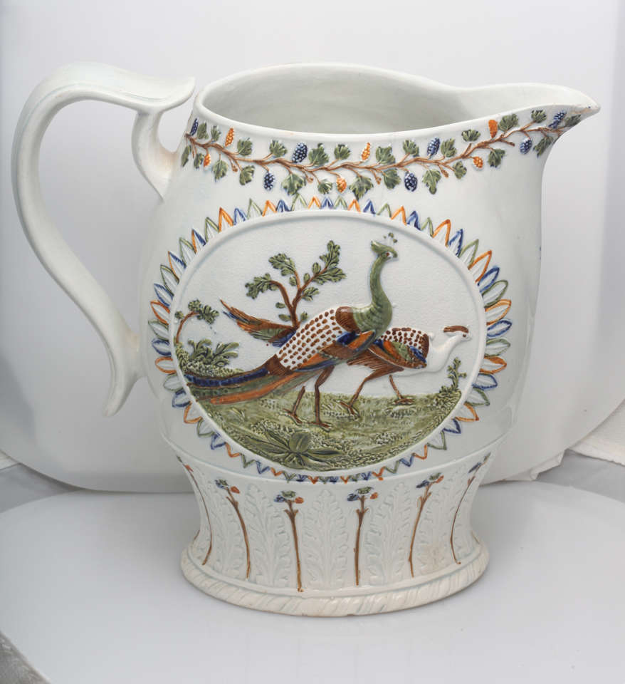 A beautiful English pearlware pitcher molded with peacocks and decorated in underglaze Pratt colors