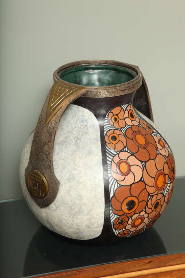 Louis Dage, circa 1920s, rare Art Deco ceramic vase with enamel decoration of stylized flower heads against a mottled light gray ground, with hammered brass rim and handles.
