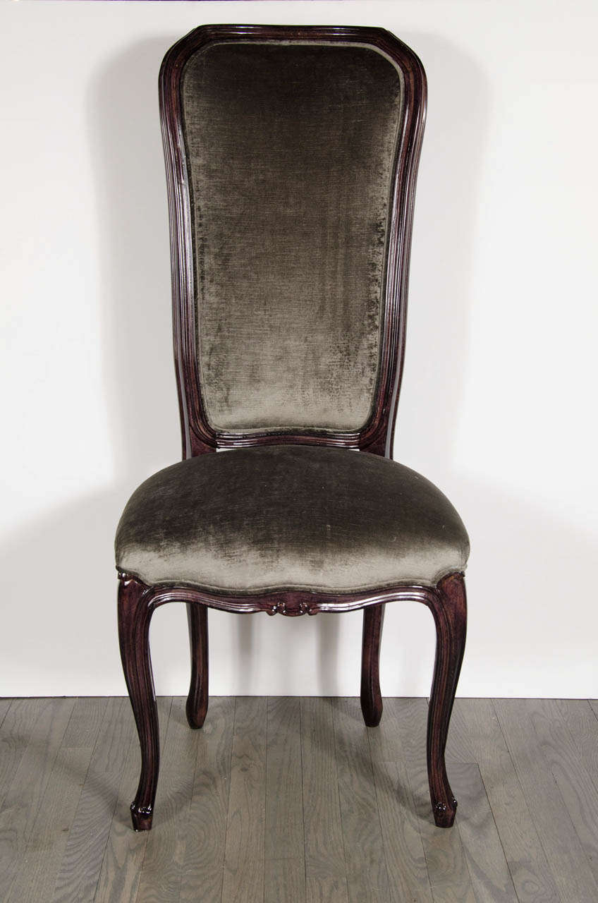 This pair of elegant 1940's occasional chairs have a high back with an ebonized walnut frame with fluted detailing. The rounded seat has been newly upholstered in a rich smoked grey velvet.  Additionally, they have cabriole legs with a scroll design