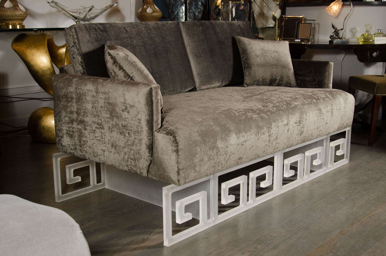 Mid-Century loveseat or daybed that appears to float atop a frosted Lucite platform base that features a bold Greek key design and newly upholstered in a rich, deep pewter gauffraged velvet gives this piece a very unique look.