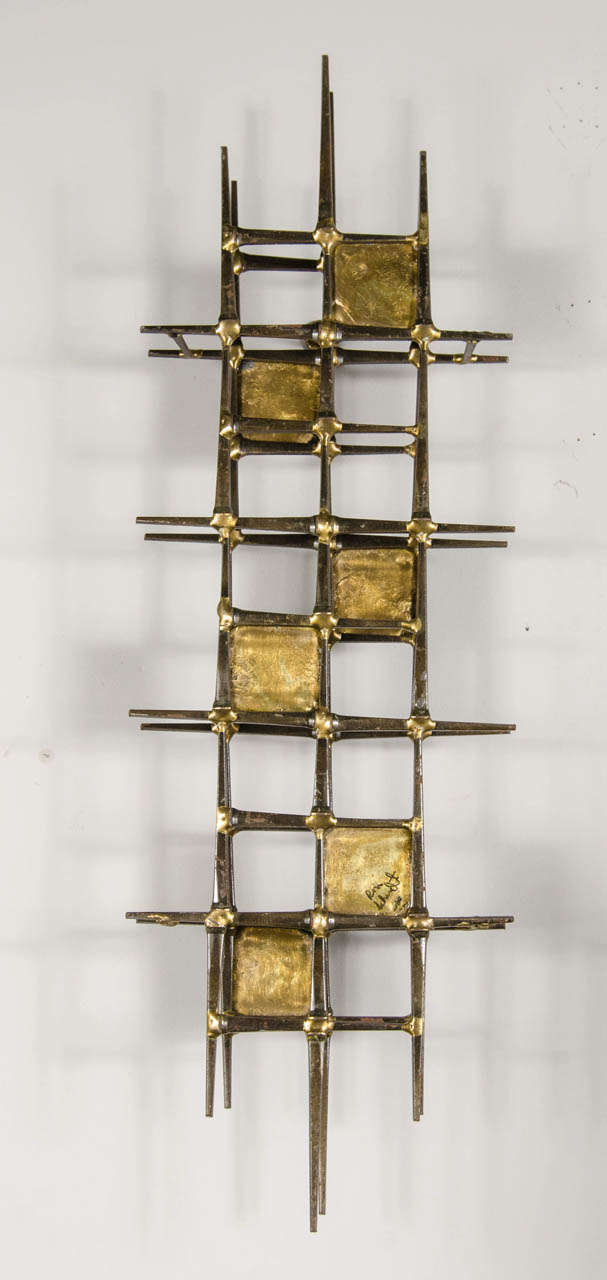 Diese Wandskulptur ist aus patiniertem Messing und wurde von dem Künstler Ron Schmidt handgefertigt. Sie ist ebenfalls signiert.