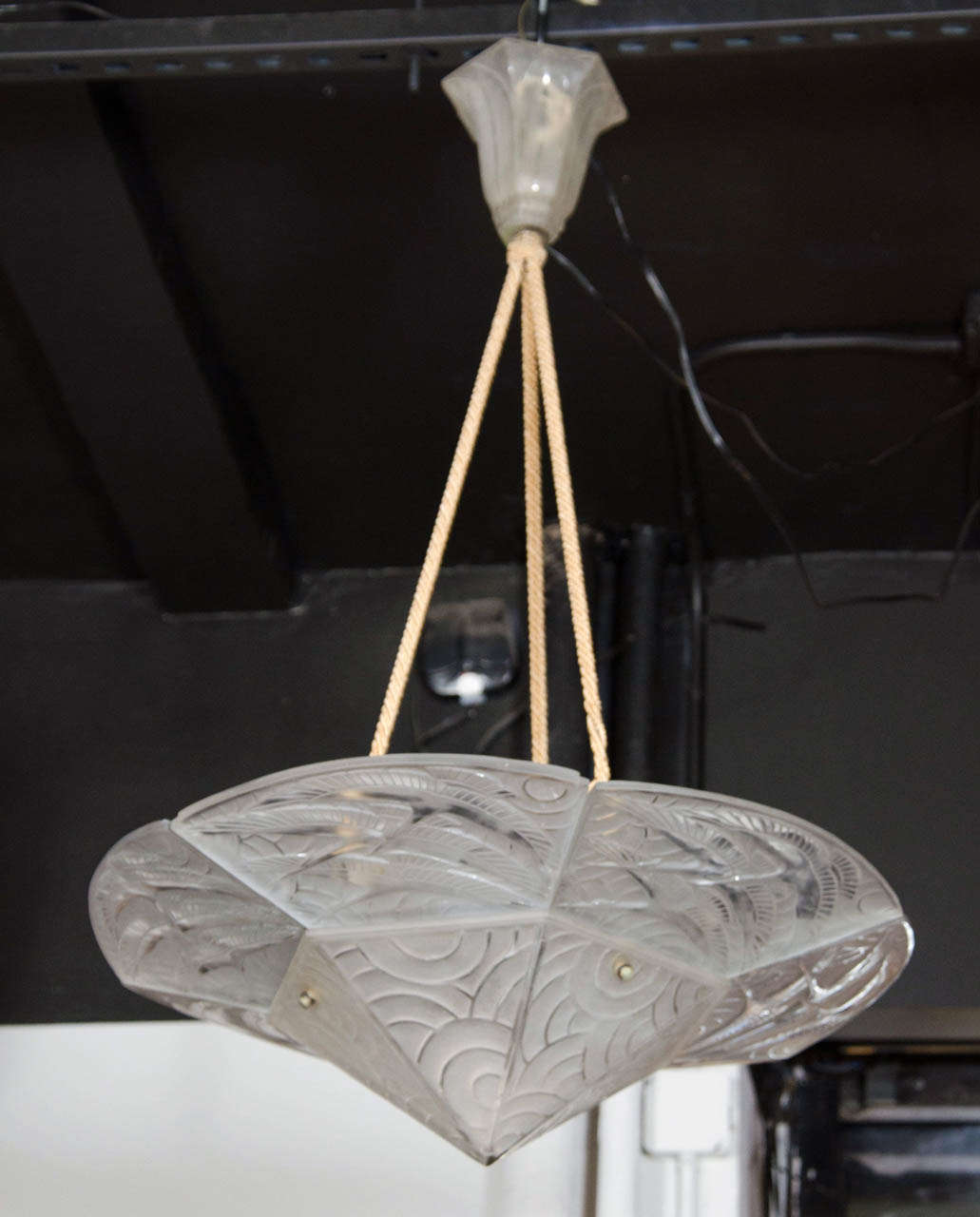 This stunning chandelier features hand blown relief frosted glass design with stylized Art Deco cranes in flight and bold geometric designs.This chandelier also features the original glass canopy.This chandelier is also signed and It has been