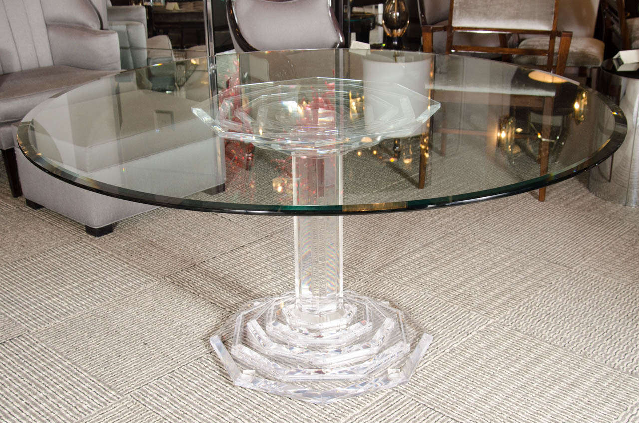 This dining table features a stacked hexagonal thick beveled and stacked lucite base and column support pedestal . It also features a thick glass top with hand beveled border details.