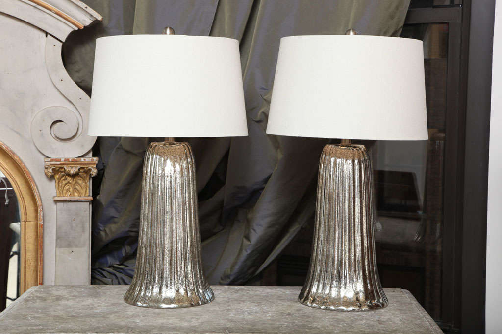 Absolutely stunning pair of oversized mercury glass lamps with a waterfall design.  Beautiful patina on glass.  Lampshades included (diameter measurements below are of lampshade). Both overall height and base height are included below.