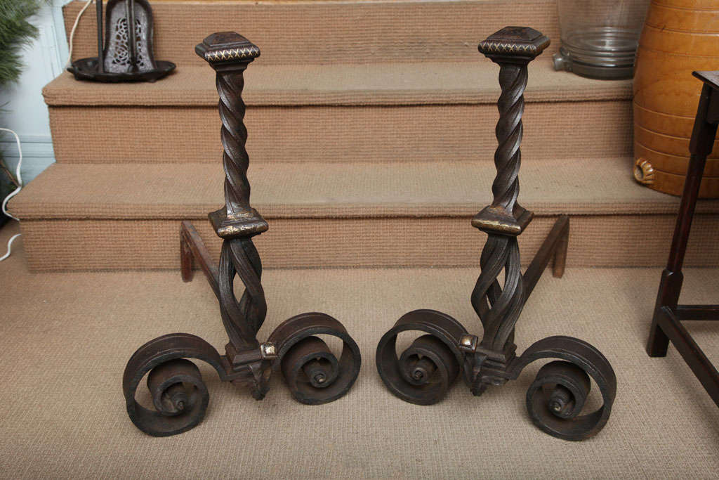 Fine pair of wrought iron Arts & Crafts andirons with bronze inlaid highlights, the shaped tops with hammered faceted finials having bronze caps and inlaid cross hatching over twist fluted shafts over square collar again with bronze detailing, over