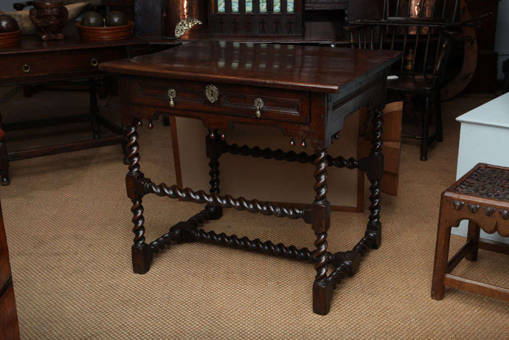 Very fine Charles II period oak side table, the three plank top over geometric molded single drawer and molded shaped apron with pear drop finials over barley twist turned legs joined by both high and low barley twist stretchers, the whole with