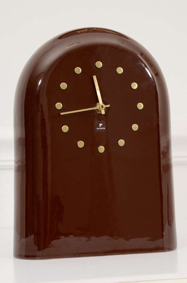 Rare Raymor table clock with ceramic body finished in a high-gloss, chocolate brown glaze. Minimalist clock face features a ring of undifferentiated brass studs to mark the hours, all very much in the style of George Nelson for Howard Miller. Signed
