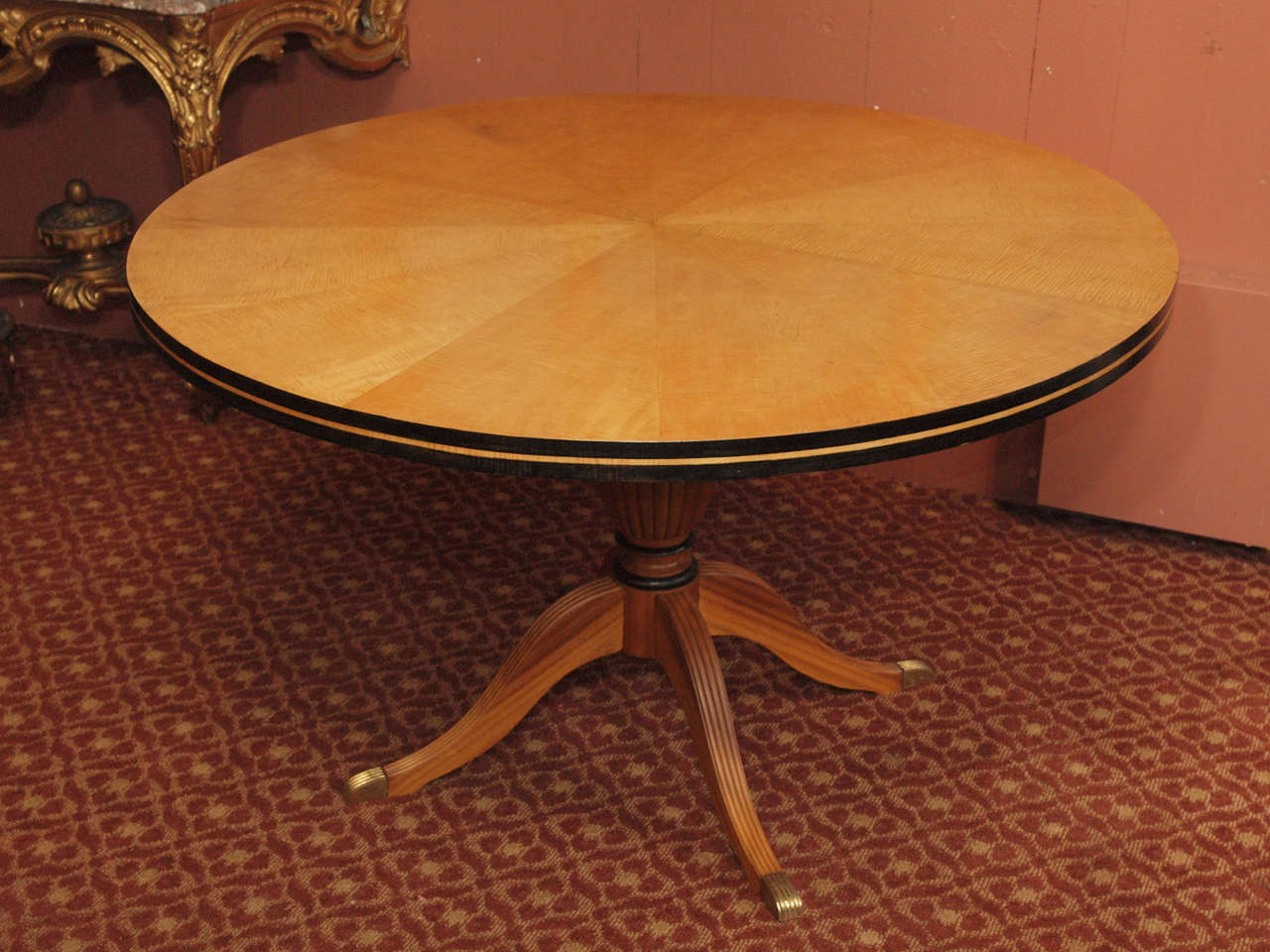 19th century English Regency style sycamore pedestal supper table with carved and ebonized decoration.