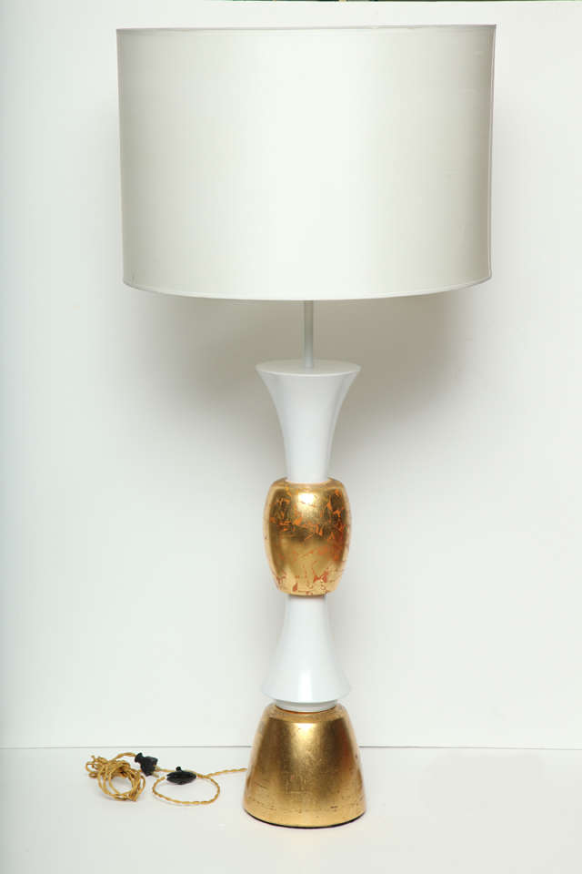 An oversize wood table lamp in white lacquer and mottled gold leaf.  USA, circa 1950.