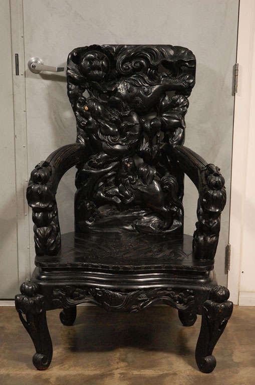 This Impressively carved  chair is decorated with Foo Dogs, Fish, Flora and Fauna. The heavily carved back has two Dogs of Foo and the pierced skirting shows a carp breaking the water. The legs, arms and back have delicate and intricate carvings