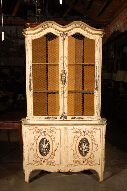 This is an interesting cabinet, thought to be Italian, circa 1930's, with hand decorative elements and wire grills to the top doors. Just the type cabinet to go into a Mediterranean, South of France, Italian setting.Jefferson West antiques offer a