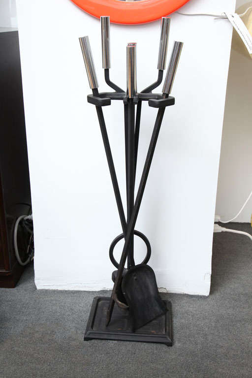Fireplace tool set in black metal with chrome handles. Circa 1980.  Includes five pieces: poker, shovel, brush, log holder and matching stand.