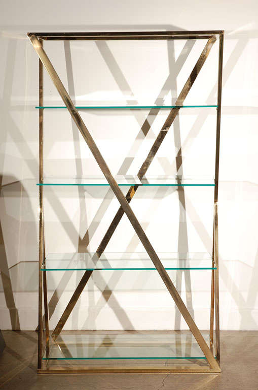 Very chic Sculptural Brass Gold and glass Italian etagere with 4 glass shelves.<br />
Modern and unusual shape with a X shapes Brass in the Manner of Milo Baughman.<br />
<br />
Mosaik provides Antiques, Art Deco, Moorish Style, Spanish, African,