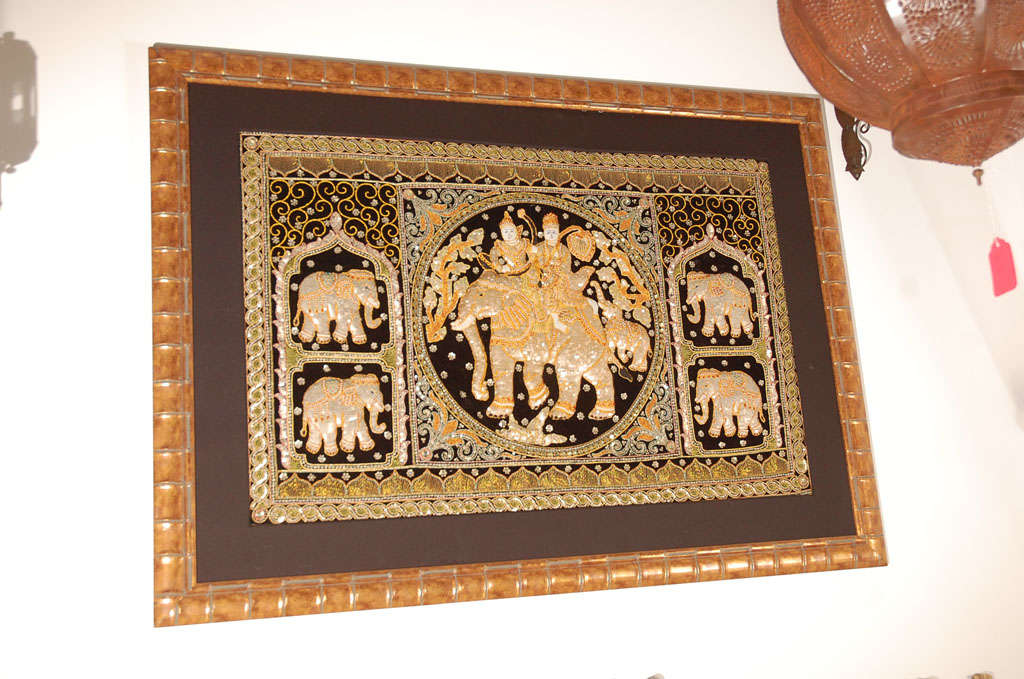 This is an ornately embroidered tapestry called kalaga from Myanmar (Burma).
Very nice wall hanging depicting an  elephant in the center with the Queen and King riding and there is 4 more elephants around with the victory posture trunk up which