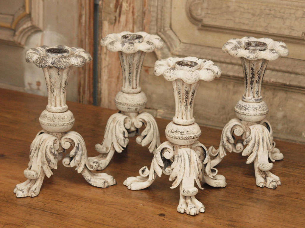 Pair of 19th century Italian painted iron candlesticks. They are reeded, have tripod claw feet  and are adorned with foliage. 