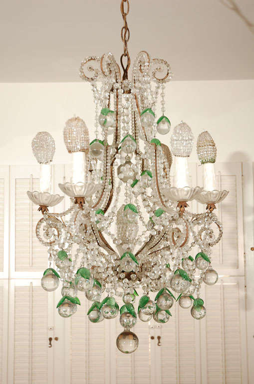 Heavily beaded Italian chandelier hung with balls and green leaves. Seven lights, one on each arm and one in the center of the frame. Beading on all arms. Beaded bulb covers not included.
Previously priced at $6,200.00 now reduced to $4,00.00.