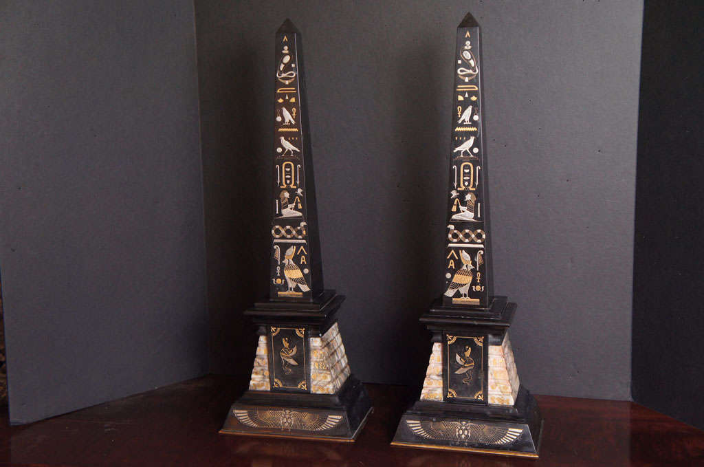 This finely detailed set of Obelisks have drama and impact. Done as a pair of black marble shafts set upon onyx plinths then set upon black marble bases with bronze trim. The whole is carved with low relief hyrogliphics. Those glyphs are then silver