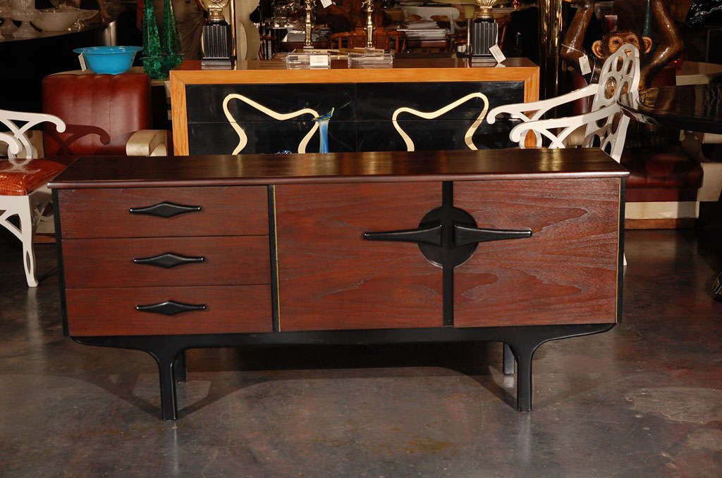 A Modernist credenza / small buffet in American walnut with two tone finish. Has three drawers and a cabinet.