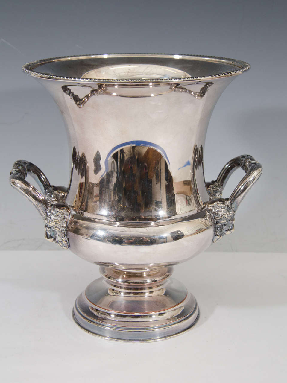 A vintage English silver plate ice bucket or champagne cooler with lion and elk design, circa 1940s.

The piece has its original removable liner.